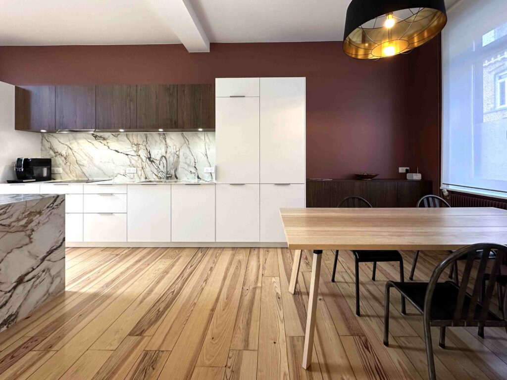 Vue cuisine, Façade blanche, plan de travail et crédence marbre, table de salle à manger