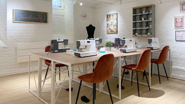 Atelier de couture, chaises terracotta rouge parquet bois tables armature métal blanc cave brique blanche