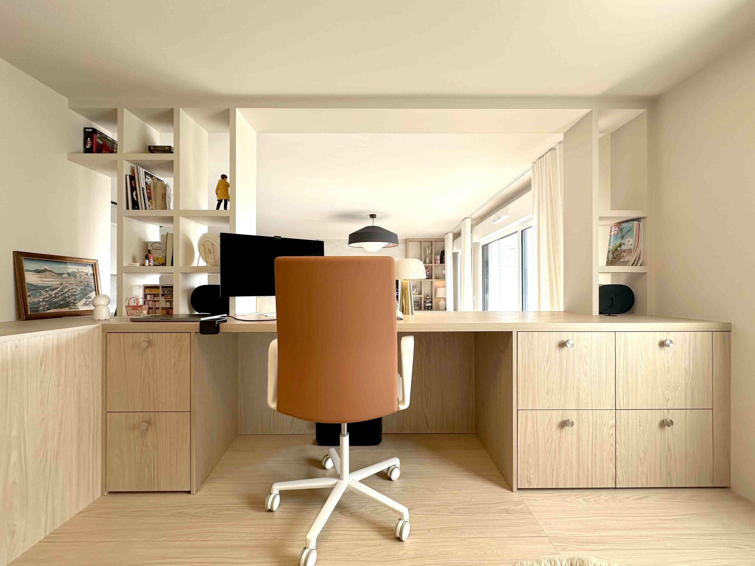 Bureau bois chaise orange et blanche bibliothèque, vue sur le séjour, estrade