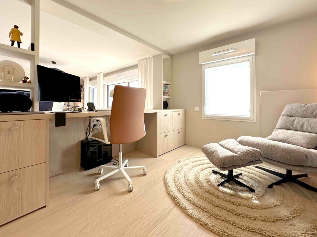 Bureau bois chaise orange et blanche bibliothèque, vue sur le séjour, estrade, fauteuil gris coin lecture